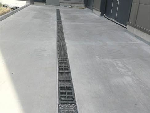 Verfugte Entwässerungsrinne in der Betonfläche vor einer Industriehalle