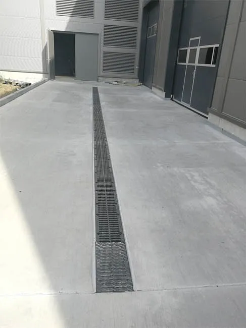 Verfugte Entwässerungsrinne in der Betonfläche vor einer Industriehalle