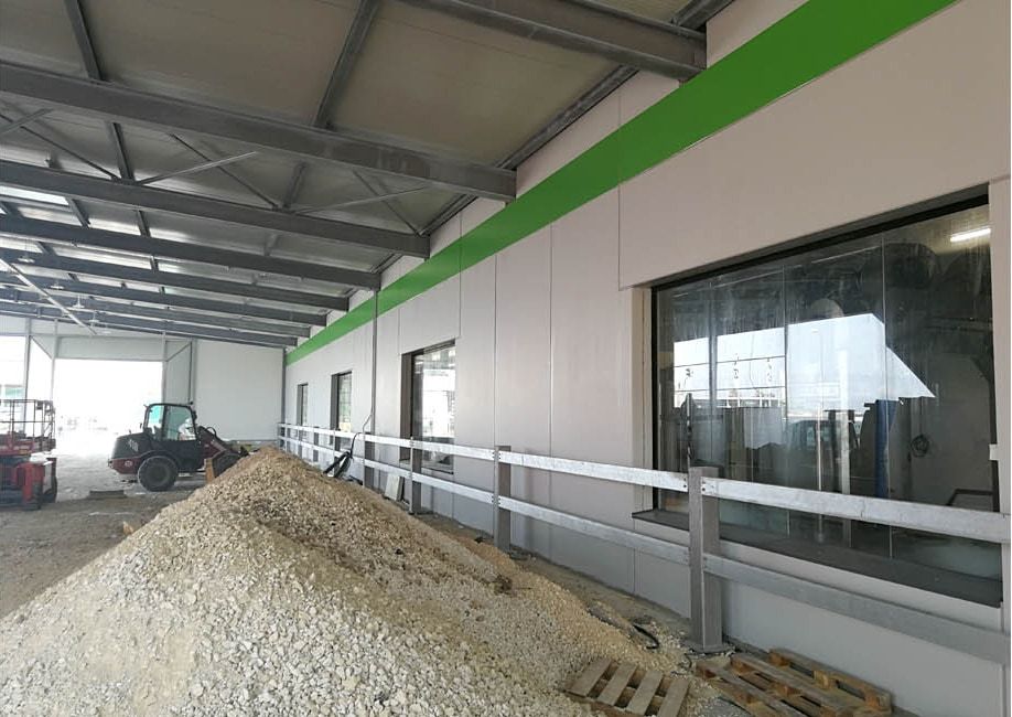 Hallenneubau mit Fassadenpaneelen und Fensteröffnungen vor der Verfugung