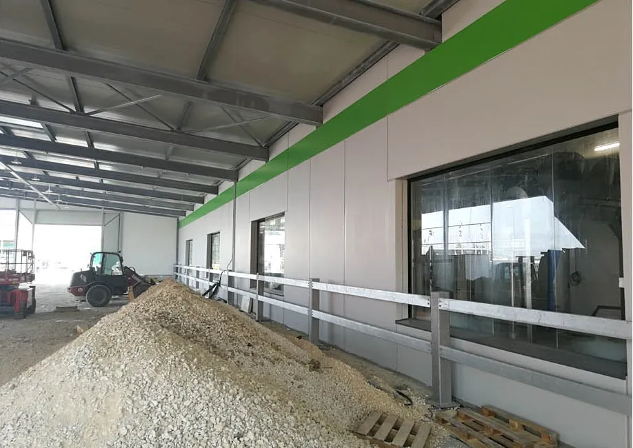 Hallenneubau mit Fassadenpaneelen und Fensteröffnungen vor der Verfugung