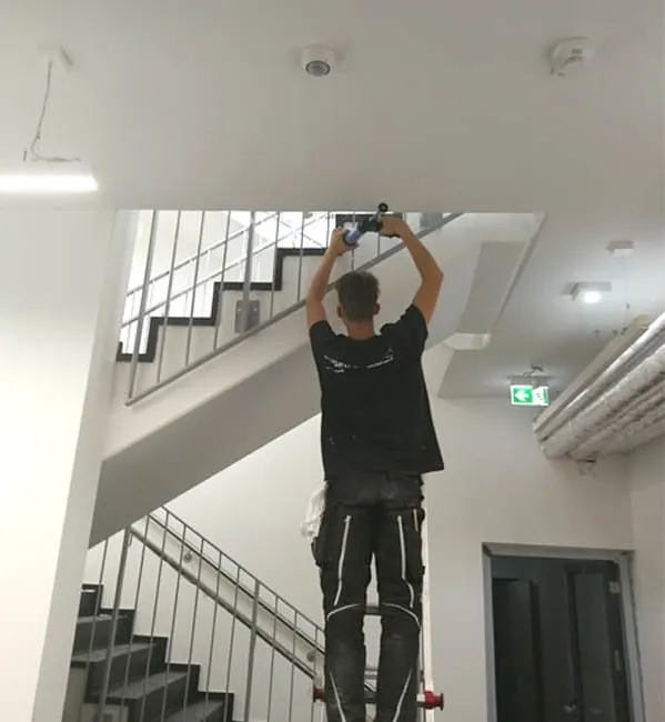 Anschlussfuge an der Decke eines Treppenhaus-Neubaus wird verfugt